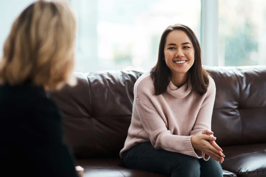 A happy young woman smiles as she benefits from CBT therapy.