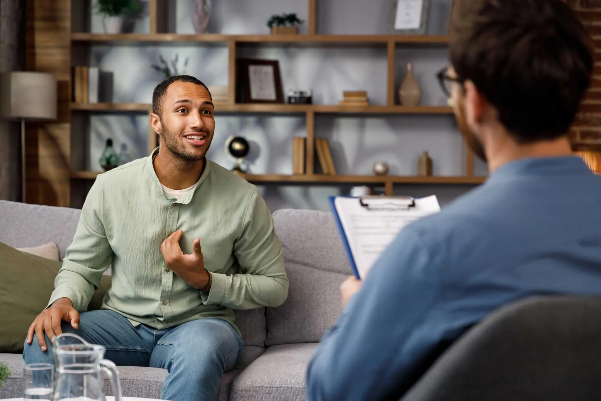 Man speaks with Psychologist during a CBT Therapy session.