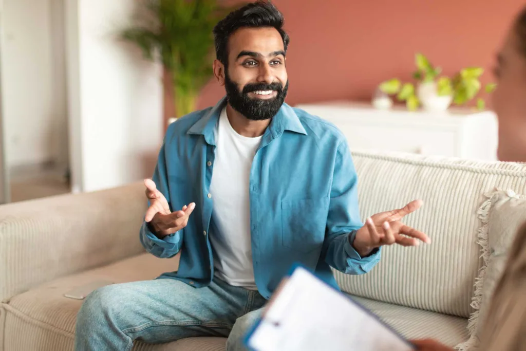 cheerful arab man speaks to a counselor during a divorce recovery session